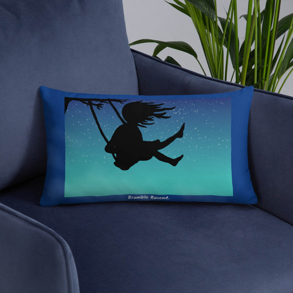 Original Swing Free design of a girl's silhouette in a tree swing against the backdrop of a blue starry sky. Rectangular image on front of pillow with blue background fabric. Pillow has design on both sides. 20 by 12 inch accent pillow. Shown on blue sofa.