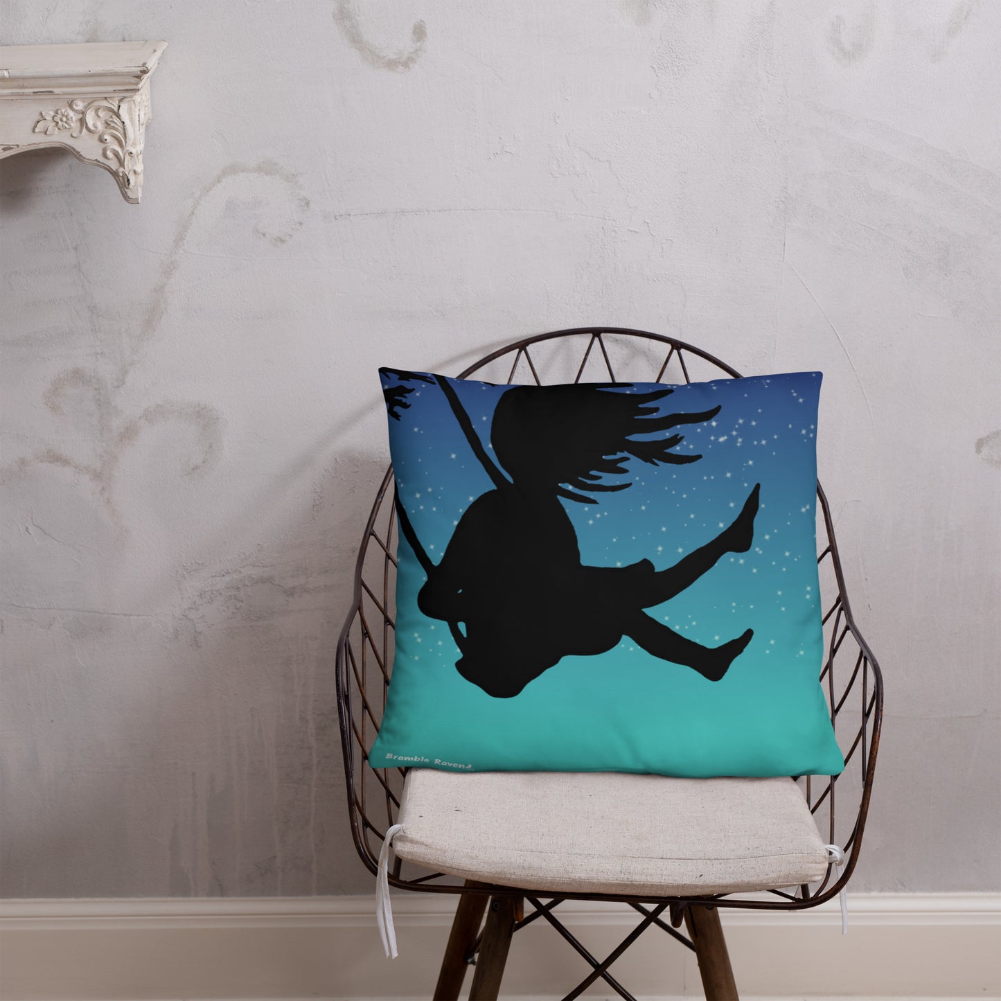 Original Swing Free design of a girl's silhouette in a tree swing against the backdrop of a blue starry sky. Rectangular image on front of pillow with blue background fabric. Pillow has design on both sides. 22 by 22 inch accent pillow. Back image shown on wicker chair.