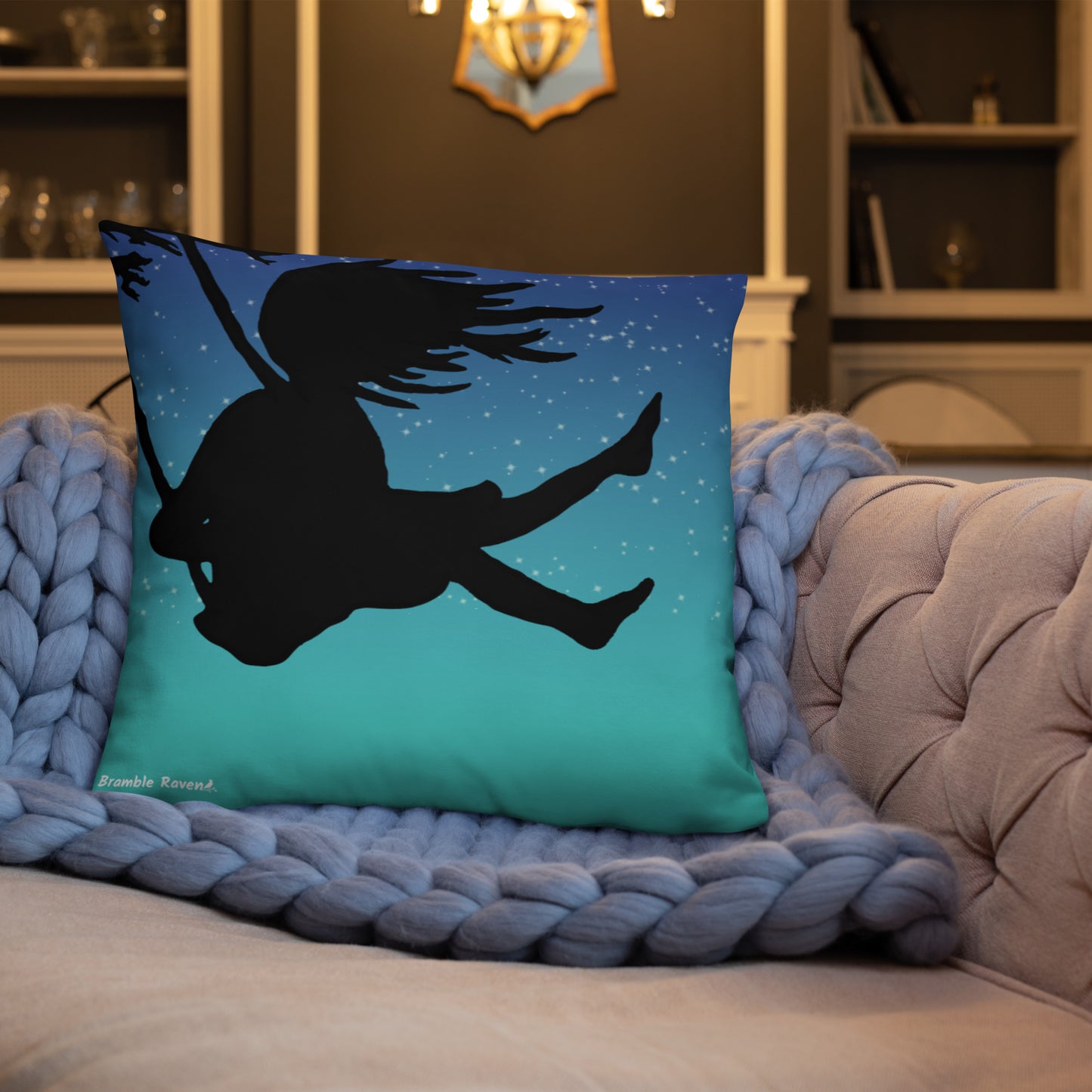 Original Swing Free design of a girl's silhouette in a tree swing against the backdrop of a blue starry sky. Rectangular image on front of pillow with blue background fabric. Pillow has design on both sides. 22 by 22 inch accent pillow. Back image shown on blue knitted blanket on tan sofa.
