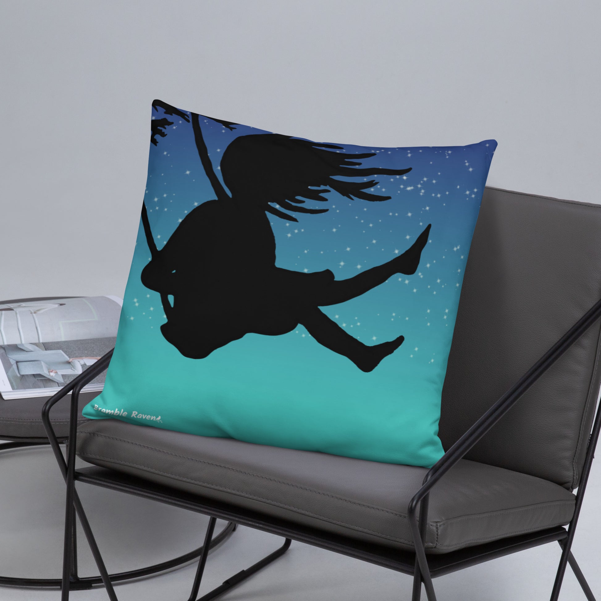 Original Swing Free design of a girl's silhouette in a tree swing against the backdrop of a blue starry sky. Rectangular image on front of pillow with blue background fabric. Pillow has design on both sides. 22 by 22 inch accent pillow. Enlarged back image shown on grey chair.