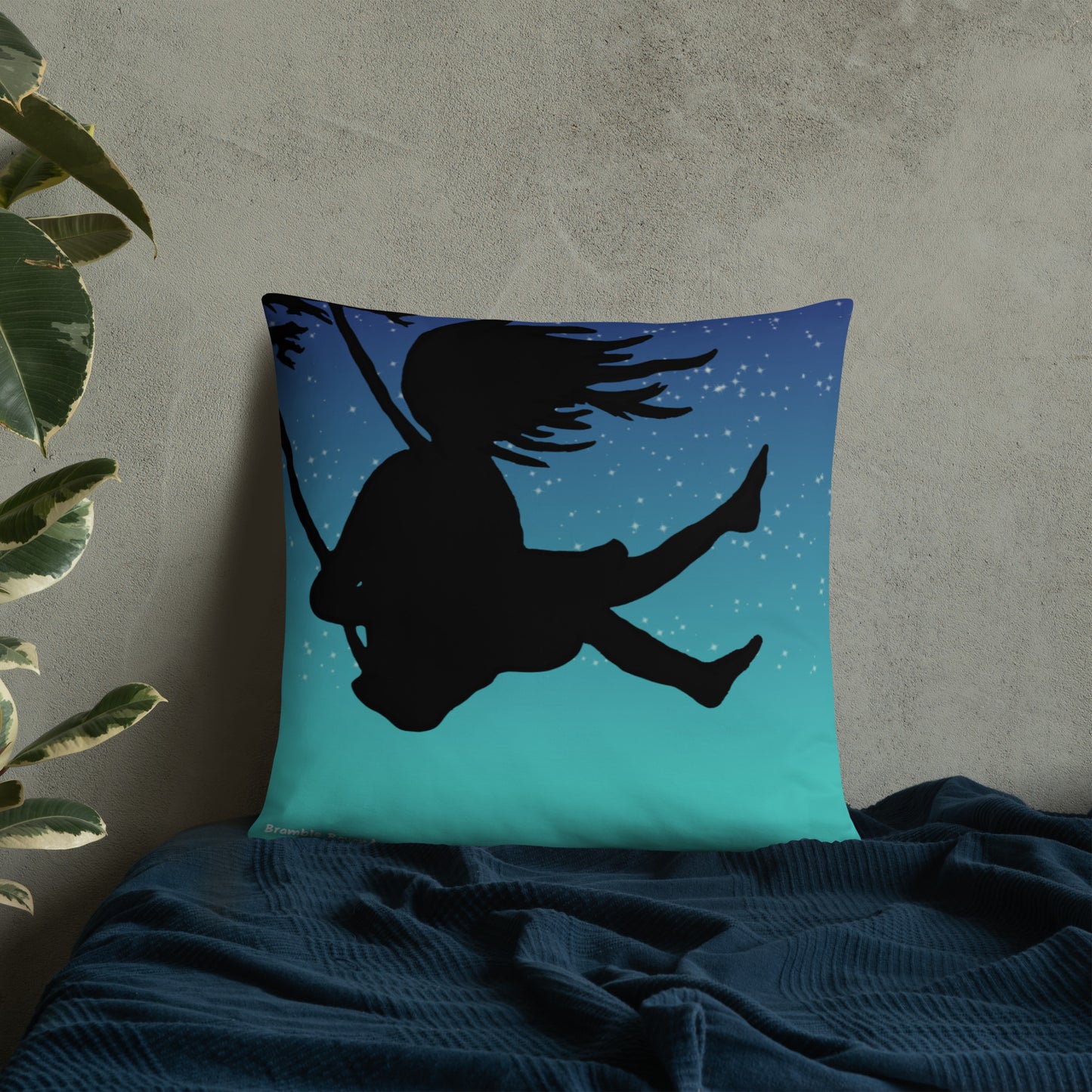 Original Swing Free design of a girl's silhouette in a tree swing against the backdrop of a blue starry sky. Rectangular image on front of pillow with blue background fabric. Pillow has design on both sides. 22 by 22 inch accent pillow. Enlarged back image shown on blue bedding.