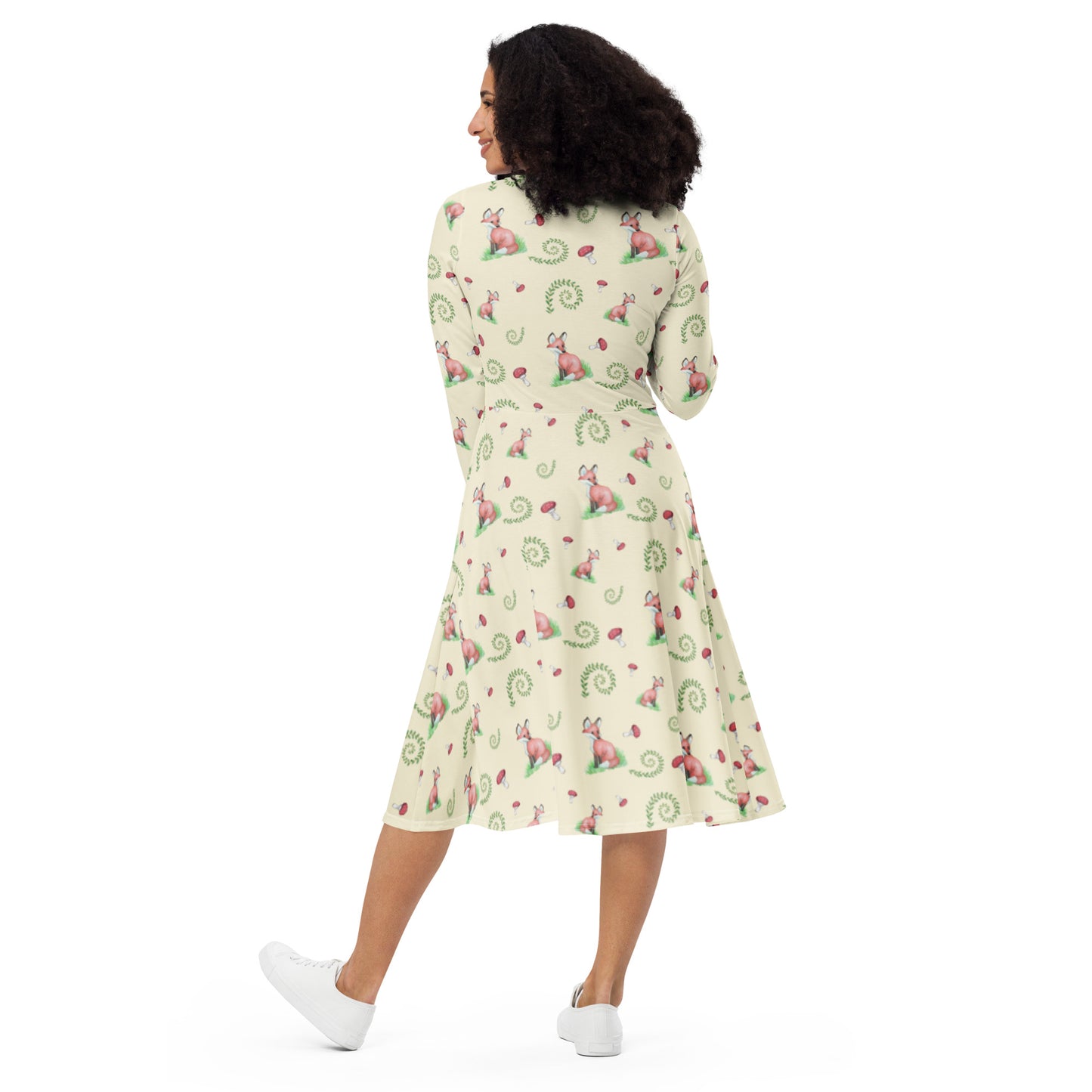 Fox pattern long sleeve midi dress with side pockets, fitted waist, and flared bottom. Foxes, ferns, and mushrooms are patterned on the apricot white fabric. Soft and comfortable. Back view on female model.