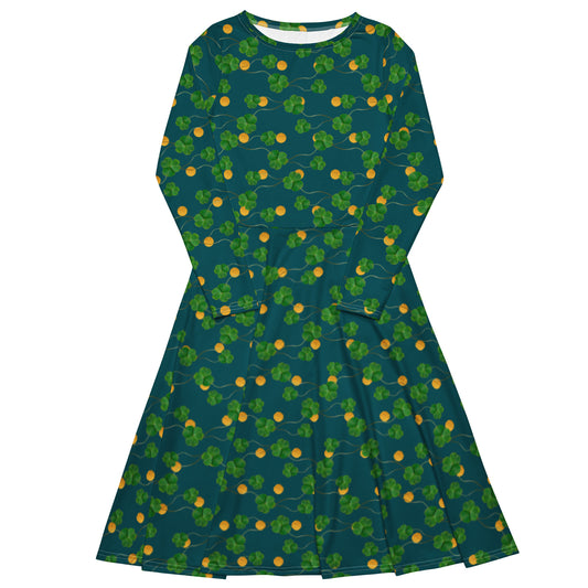 Lucky clover long sleeve midi dress. Clover and gold coins patterned across dark blue fabric. It has a boat neckline, fitted waist, flared bottom, and side pockets.