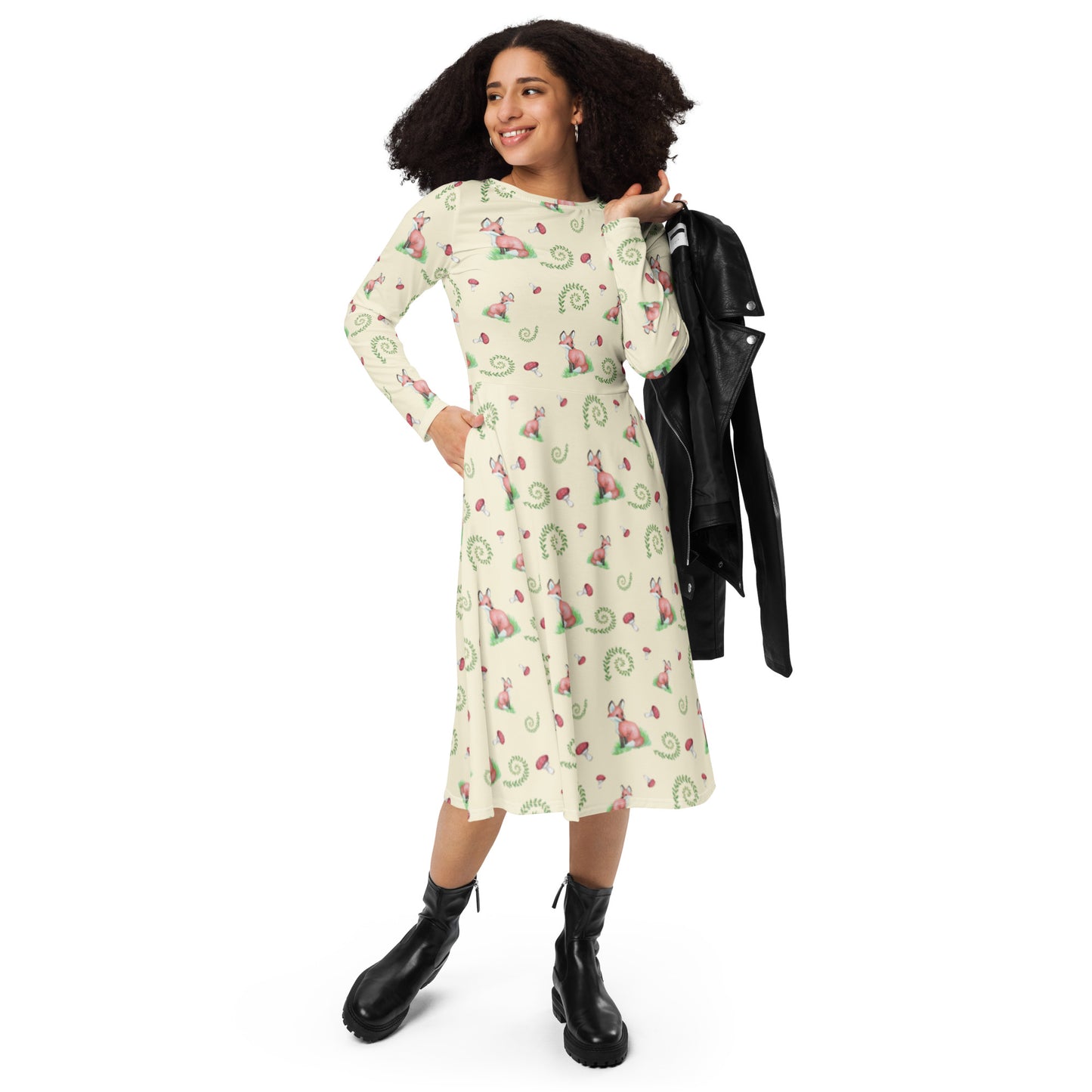 Fox pattern long sleeve midi dress with side pockets, fitted waist, and flared bottom. Foxes, ferns, and mushrooms are patterned on the apricot white fabric. Soft and comfortable. Shown on model with black jacket over her shoulder.