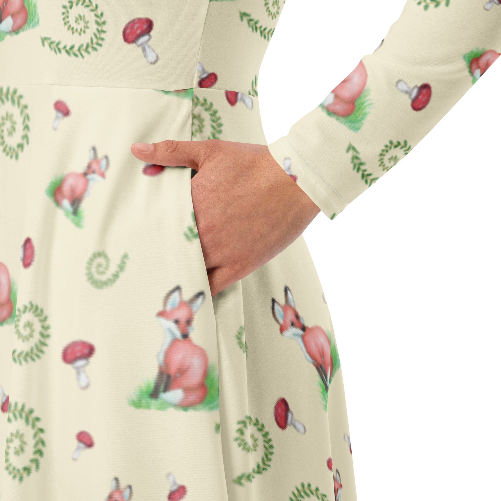 Fox pattern long sleeve midi dress with side pockets, fitted waist, and flared bottom. Foxes, ferns, and mushrooms are patterned on the apricot white fabric. Soft and comfortable. Detail image of model's hand in a side pocket.
