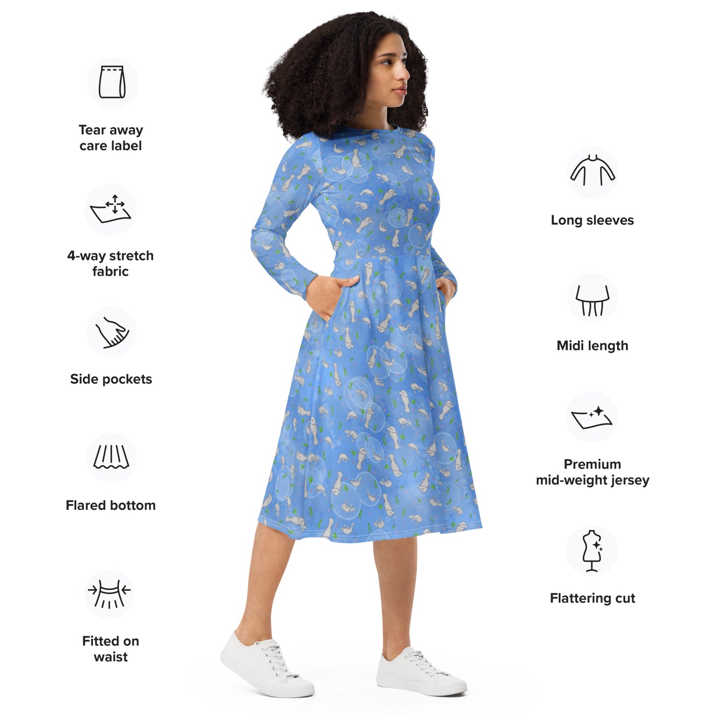 Long sleeve midi dress with fitted waist, flared bottom, and side pockets. Features a patterned design of manatees, seashells, seaweed, and bubbles on an ocean blue background. Shown on female model facing right.