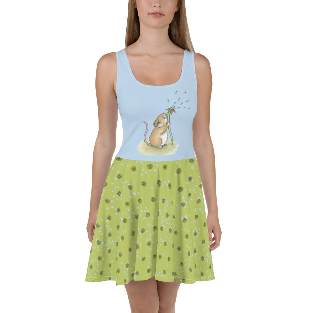 Sleeveless skater dress featuring Dandelion Wish design of a mouse making a wish on a dandelion fluff on a blue top. The mid-thigh length flared green skirt features flowers and dot details. Also has an elastic waistline. Shown on female model.
