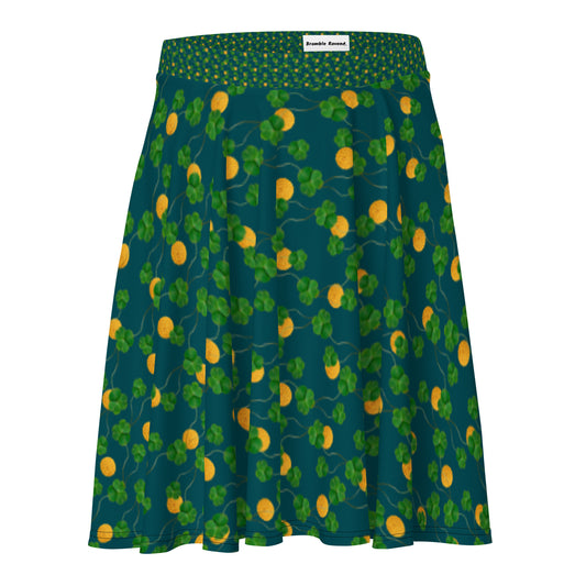 Lucky gold coin and clover skater skirt. Mid-thigh length flared skirt with elastic waistband.  Features pattern of gold coins and clovers on a dark blue-green background.