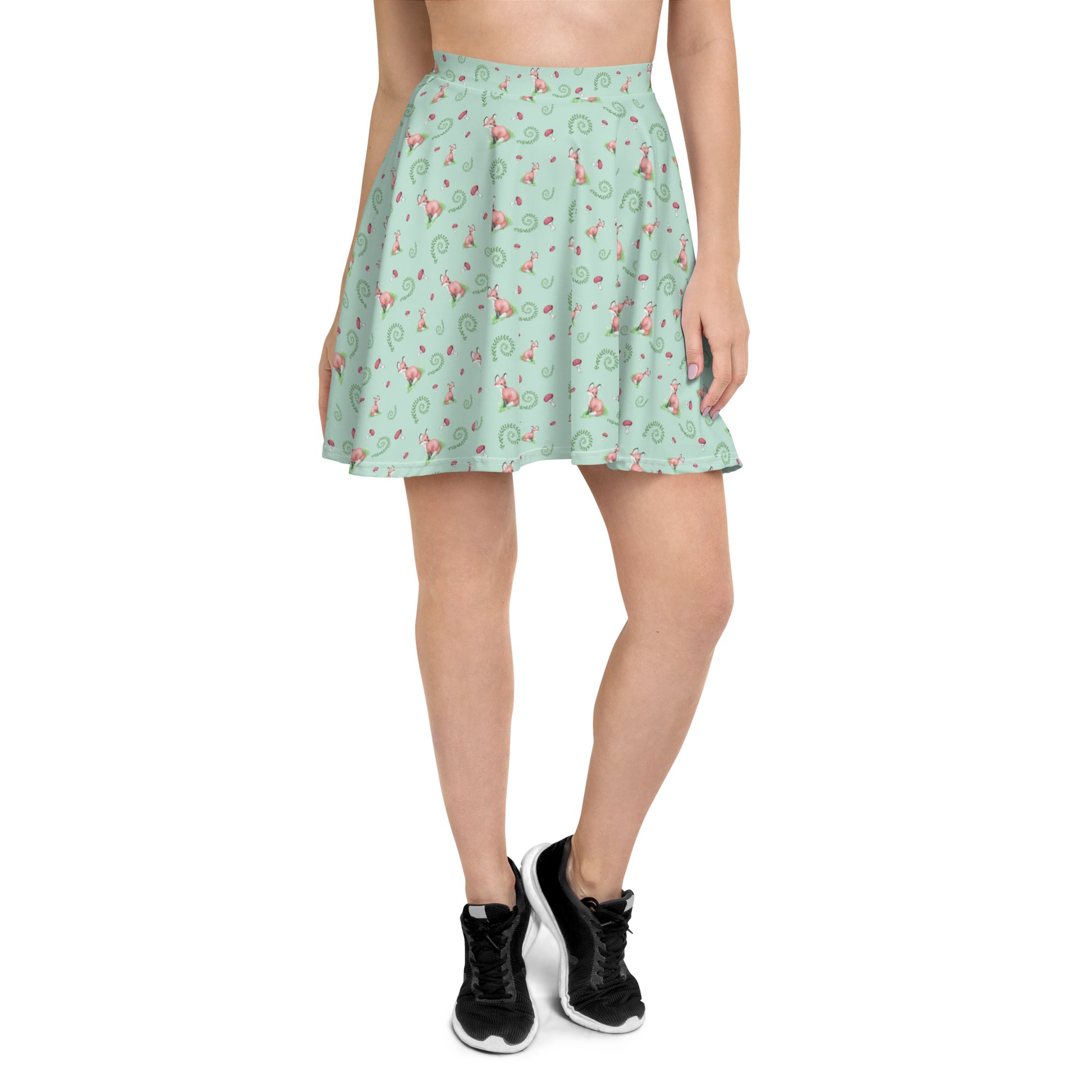 Forest Fox patterned skater skirt with mushrooms and ferns. Flared cut, mid-thigh length with elastic waist. Shown on female model with black shoes.