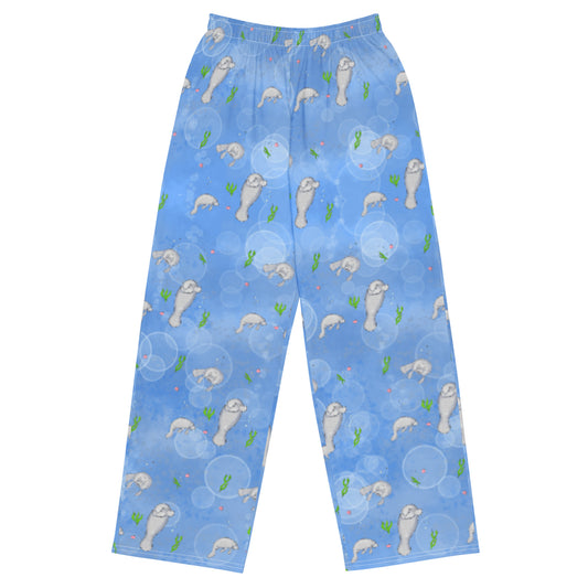 Unisex wide leg pants with elastic waistband, white draw cord, and side pockets. Features a patterned design of manatees, seashells, seaweed and bubbles on an ocean blue background.