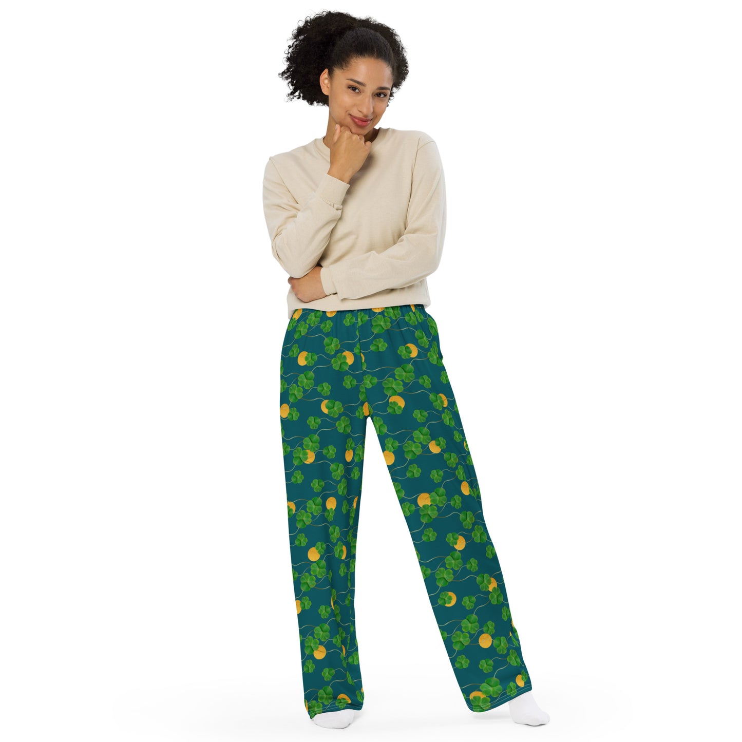 Unisex wide leg pants with side pockets, elastic waistband and drawstring.  Design features pattern of three-leaf clover and lucky gold coins on a blue-green background. Shown on female model.