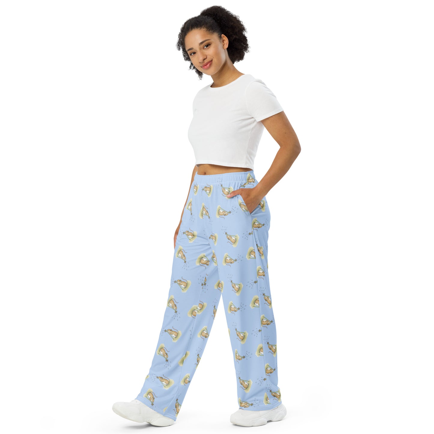 Unisex wide leg polyester pajama pants. Features dandelion wish patterned design on a light blue fabric. Has elastic waistband and white drawstring. Side pockets. Shown on female model.