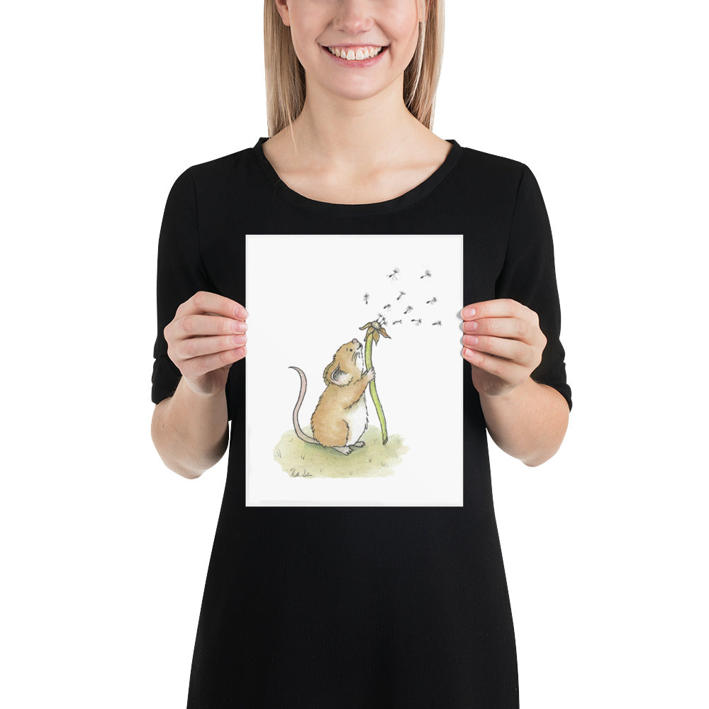 8x10 matte paper art print. Giclée quality printing. Design is a watercolor painting of a cute mouse blowing the seeds off a dandelion stem. Shown in the hands of a female model.