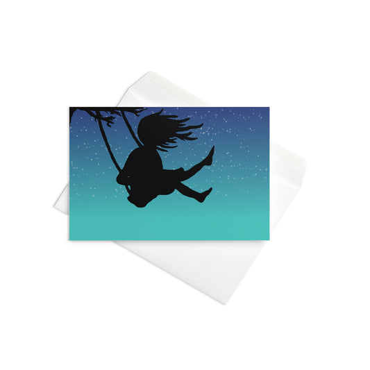 4 by 6 inch Night Swing greeting card. Shows silhouette of a girl in a tree swing against a starry summer night sky. Comes with white envelope. Inside is blank. Made on durable paperboard with vibrant printing.