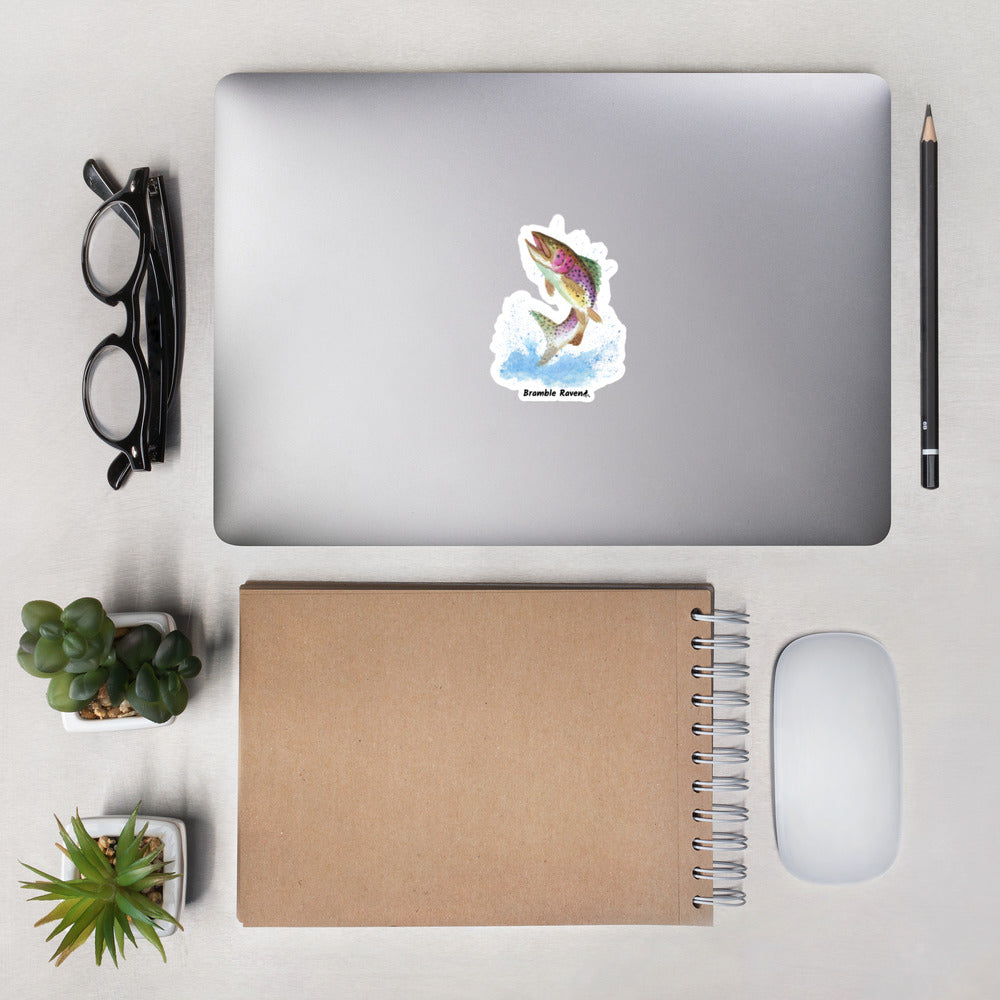4 inch kiss-cut vinyl sticker with white border. Features original watercolor painting of a rainbow trout leaping from the water. Shown on a laptop.