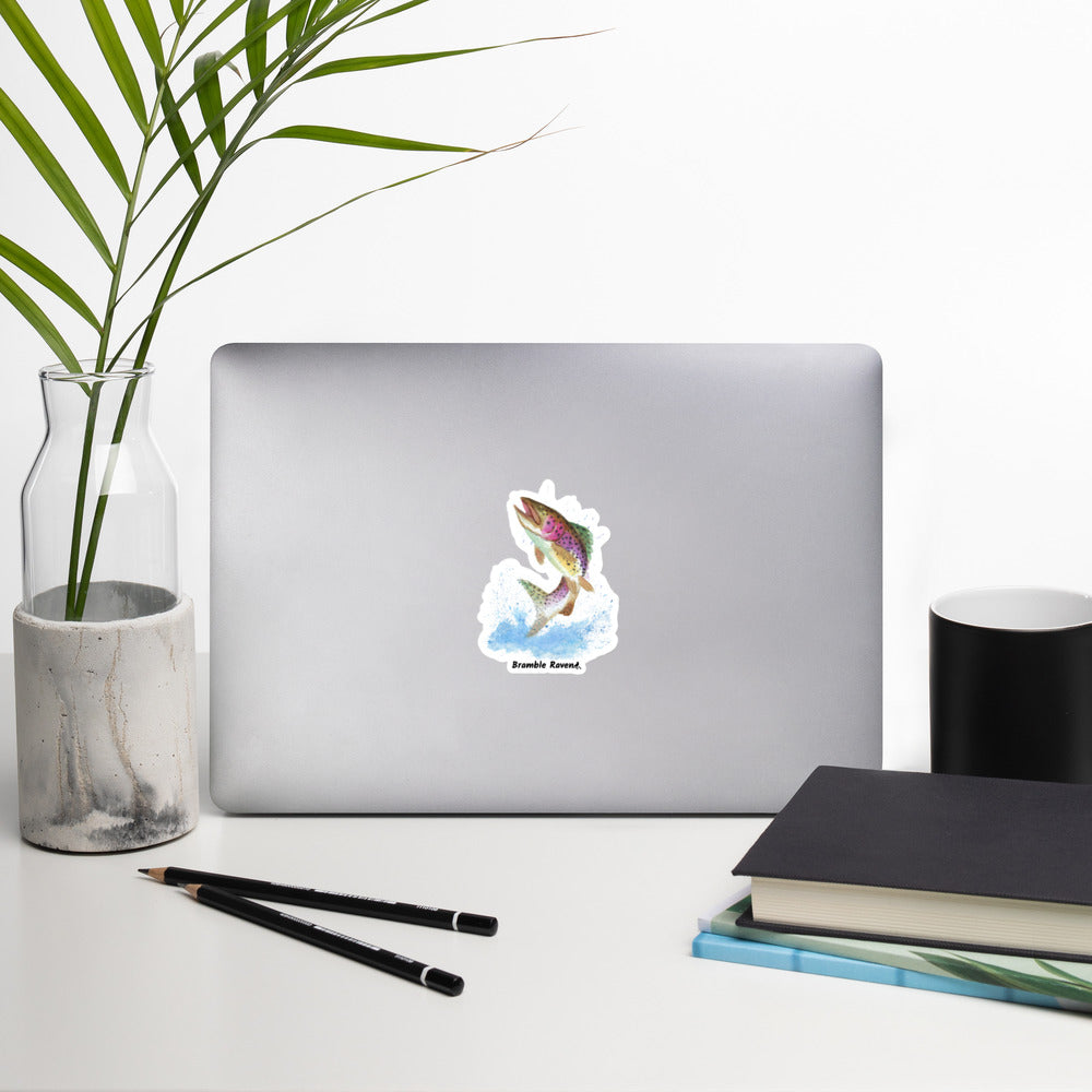 4 inch kiss-cut vinyl sticker with white border. Features original watercolor painting of a rainbow trout leaping from the water. Shown on a laptop.