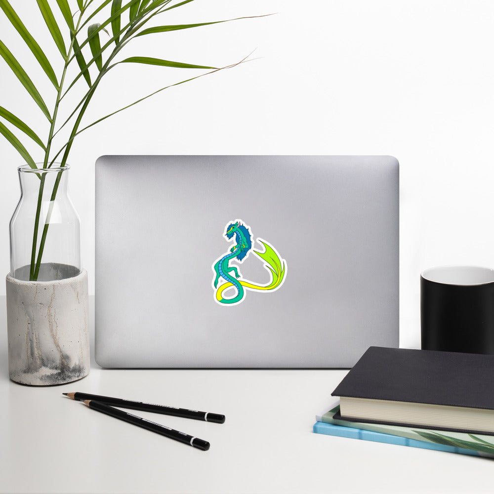 Mikori the Fuzzy Noodle Dragon. Original character design kiss-cut vinyl sticker with white border. 4 inches tall. Shown on a laptop.