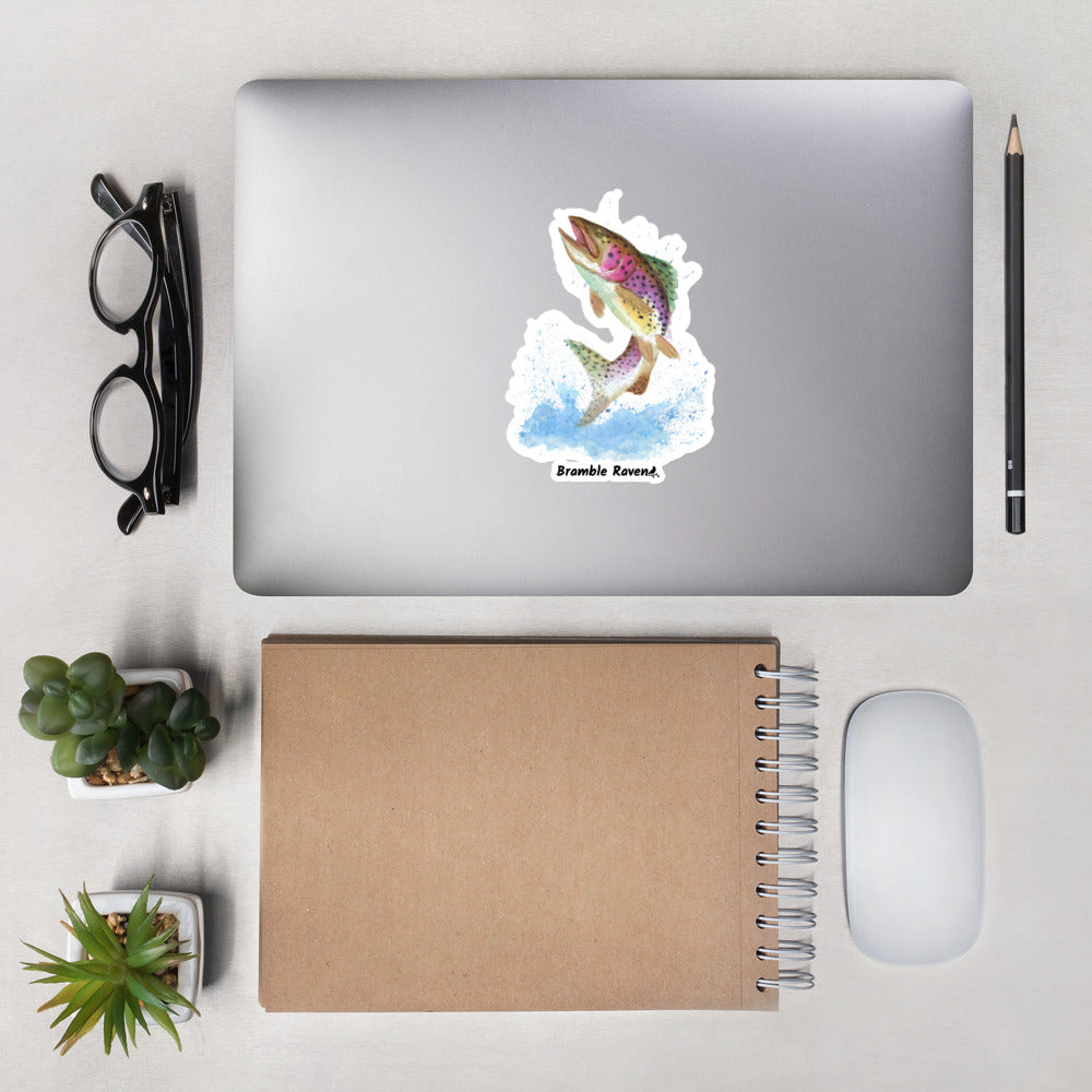 5.5 inch kiss-cut vinyl sticker with white border. Features original watercolor painting of a rainbow trout leaping from the water. Shown on a laptop.