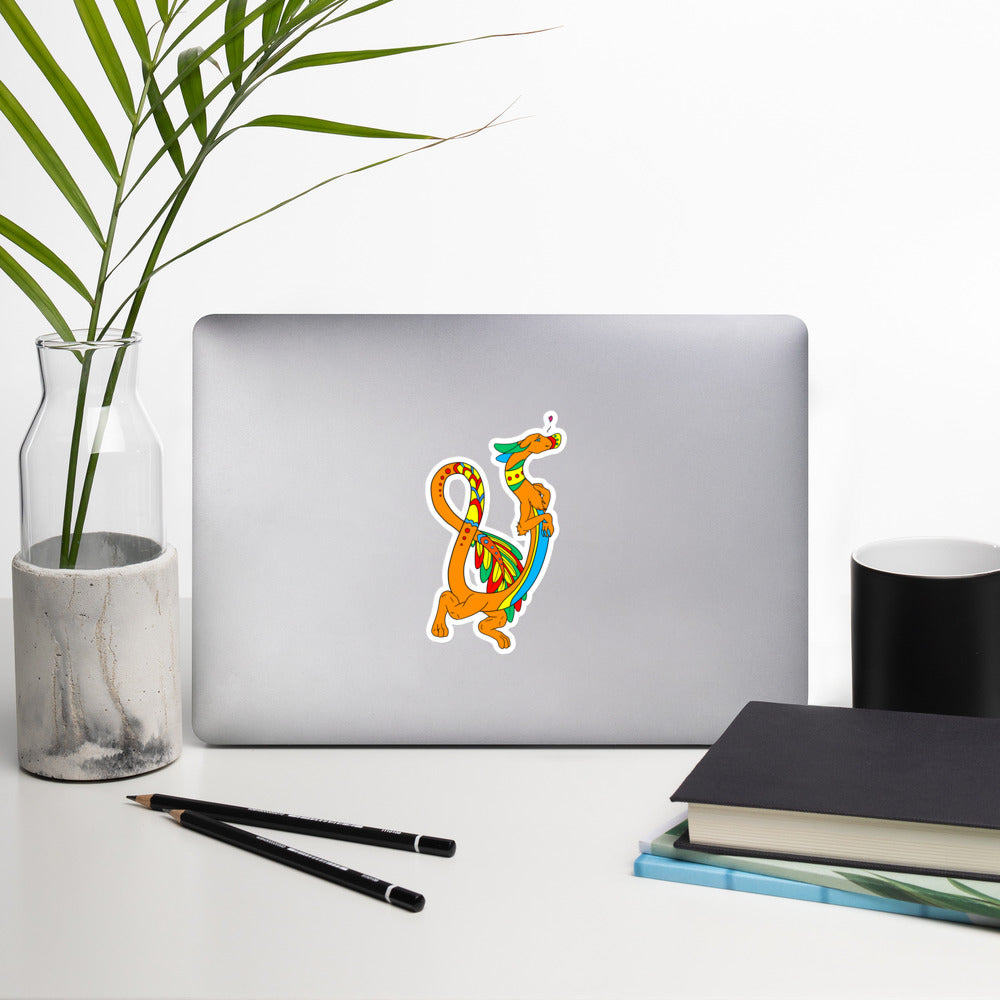 Domingo the Aztec Fuzzy Noodle Dragon. Original character design kiss-cut vinyl sticker with white border. 5.5 inches tall. Shown on a laptop.