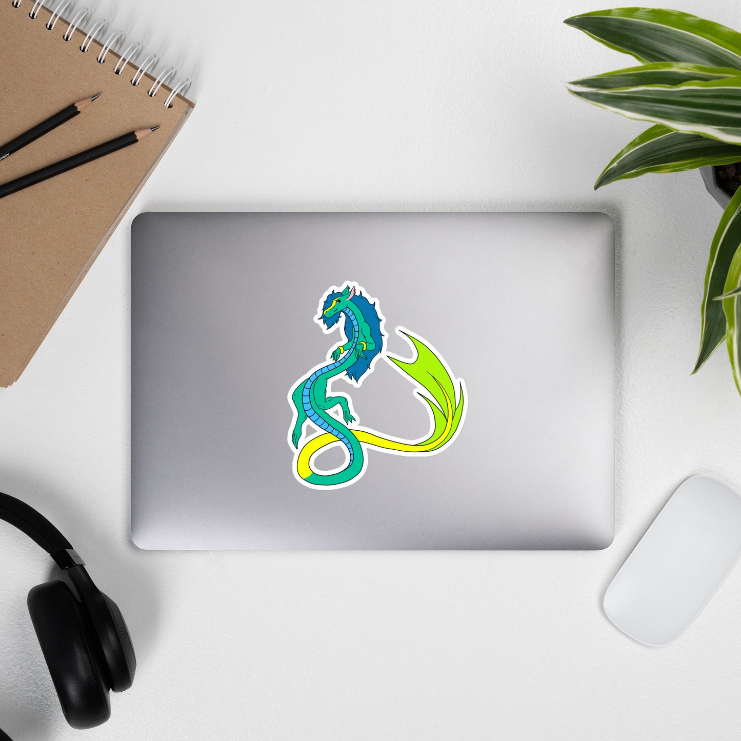 Mikori the Fuzzy Noodle Dragon. Original character design kiss-cut vinyl sticker with white border. 5.5 inches tall. Shown on a laptop.