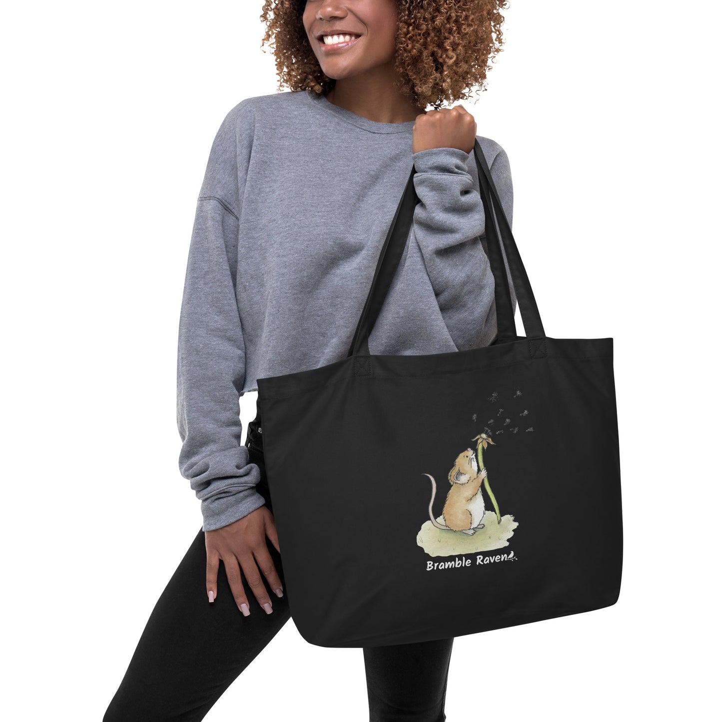 Original watercolor Dandelion wish design of a cute mouse blowing dandelion seeds. Printed on large black colored eco tote. 20 by 14 by 5 inches. Shown being held by female model.