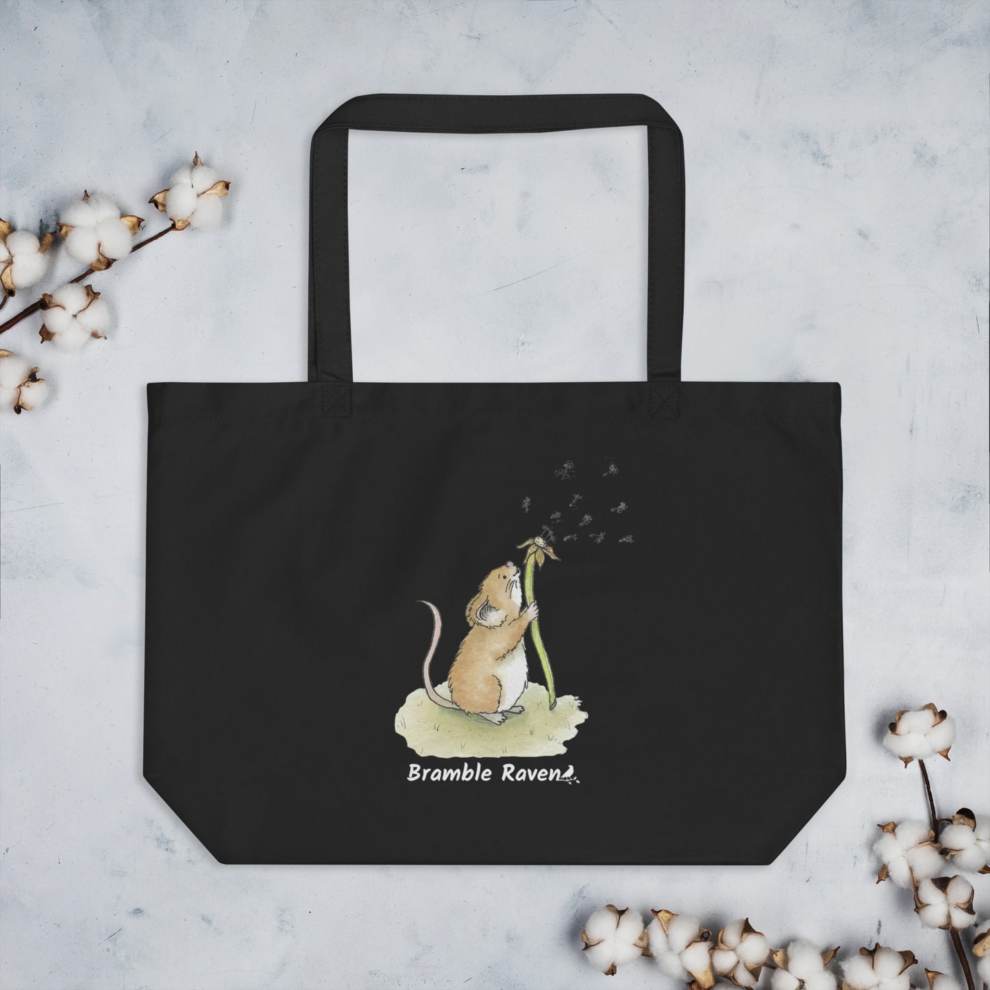 Original watercolor Dandelion wish design of a cute mouse blowing dandelion seeds. Printed on large black colored eco tote. 20 by 14 by 5 inches. Shown on tabletop with cotton plant accents.