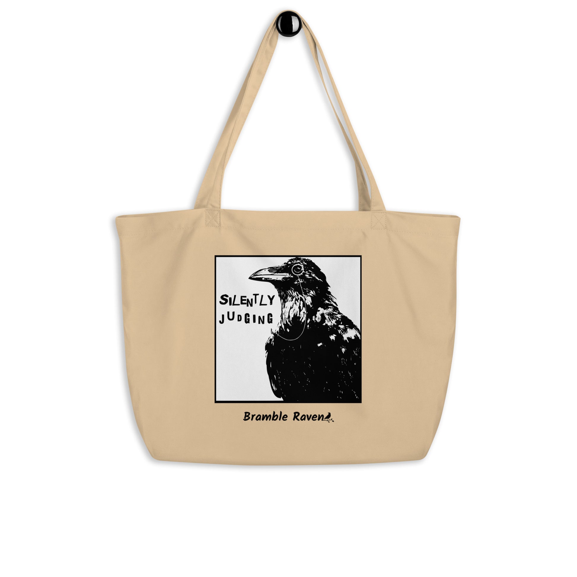 Original Silently Judging crow design. Silently Judging text. Black crow with monocle in square frame. Printed on large oyster-colored eco tote. 20 by 14 by 5 inches. 100% recycled cotton.