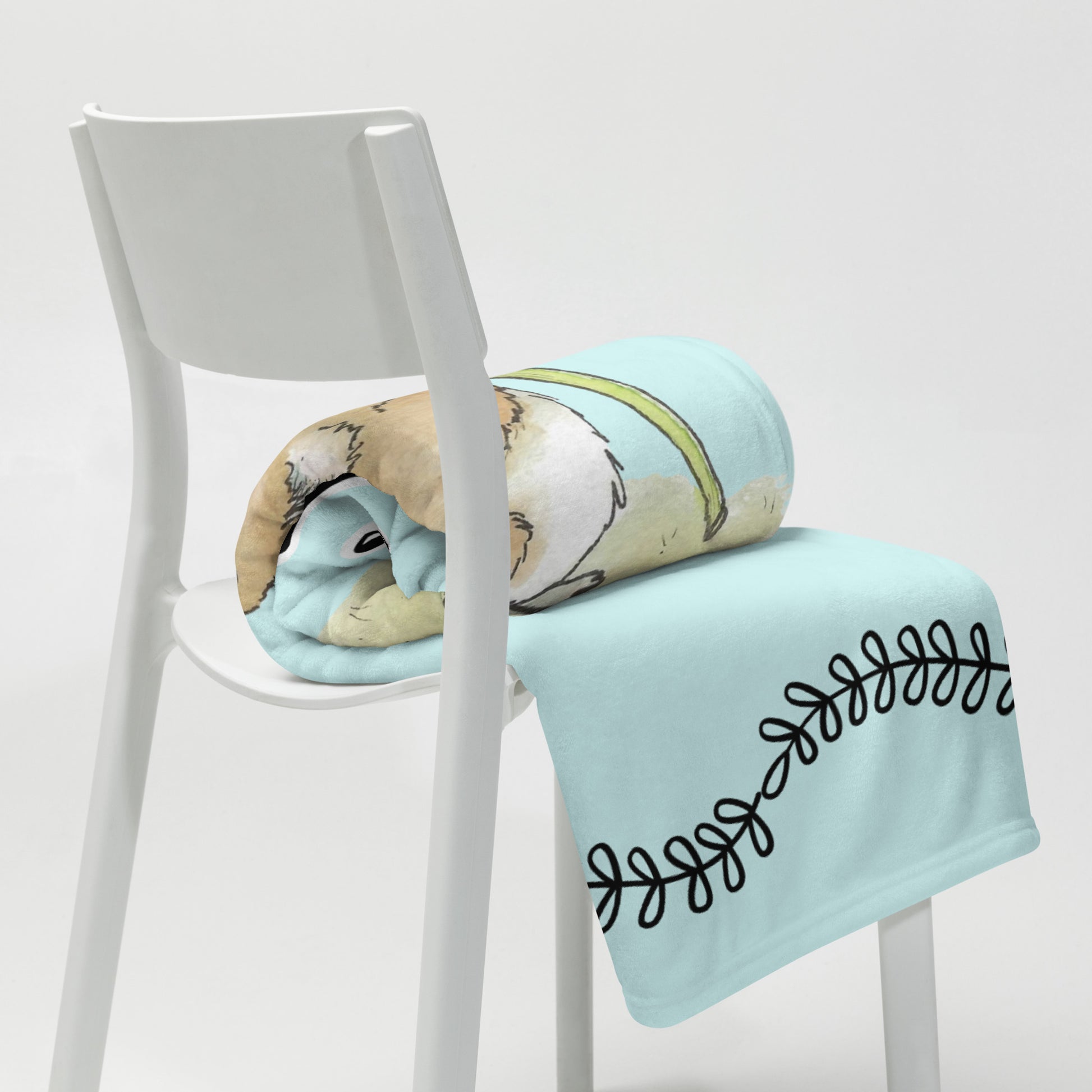Original Dandelion Wish design of cute watercolor mouse blowing dandelion seeds on a light blue background. Black vine border on top and bottom. Make a Wish phrase below mouse graphic. 50 by 60 inch throw blanket rolled on white chair.