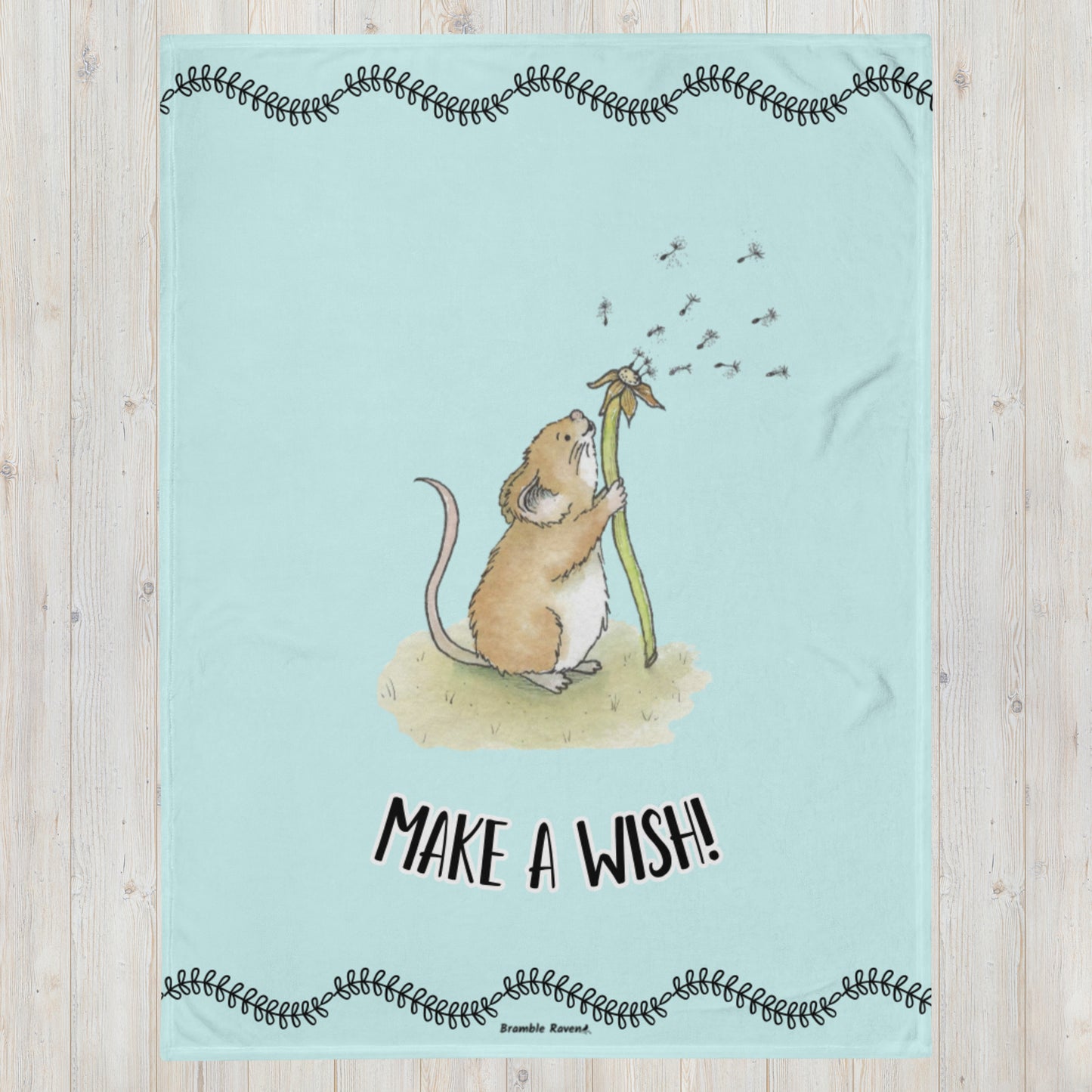 Original Dandelion Wish design of cute watercolor mouse blowing dandelion seeds on a light blue background. Black vine border on top and bottom. Make a Wish phrase below mouse graphic. 60 by 80 inch throw blanket. 