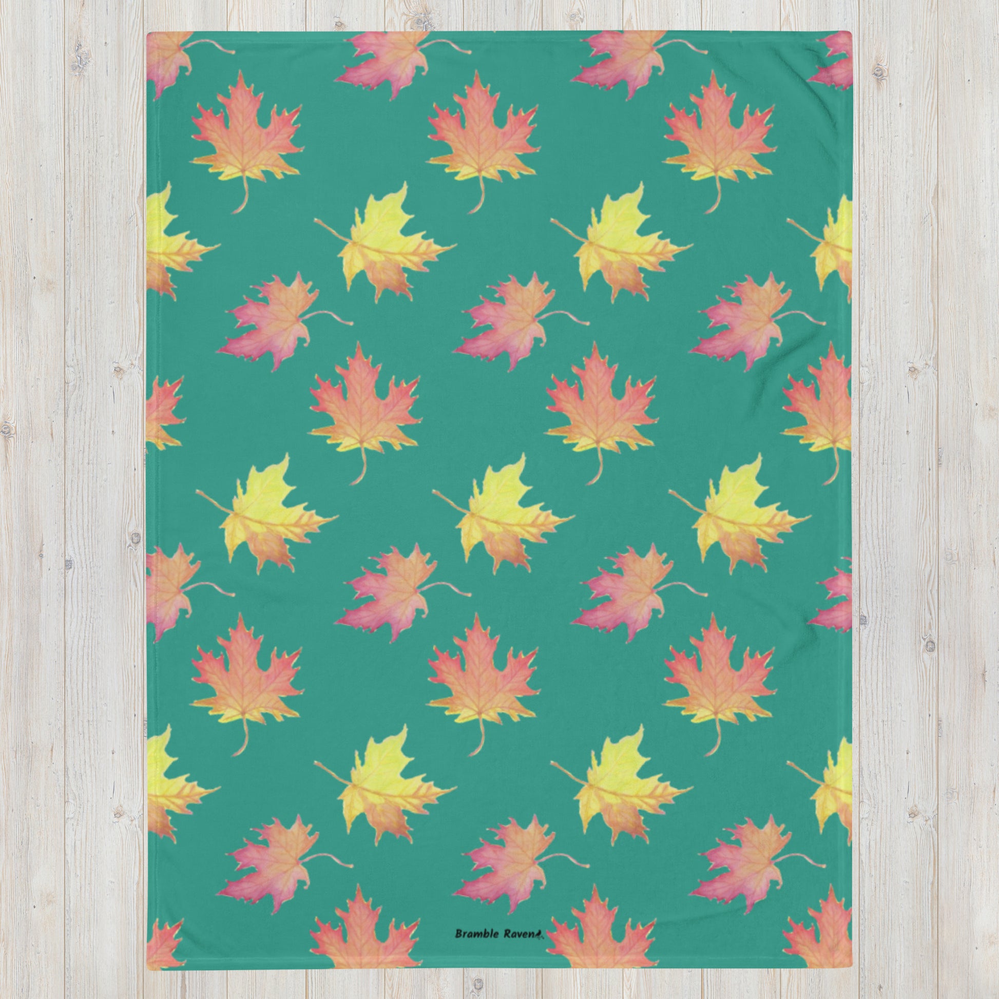 60 by 80 inch soft throw blanket featuring watercolor fall leaves patterned on a dark green background.