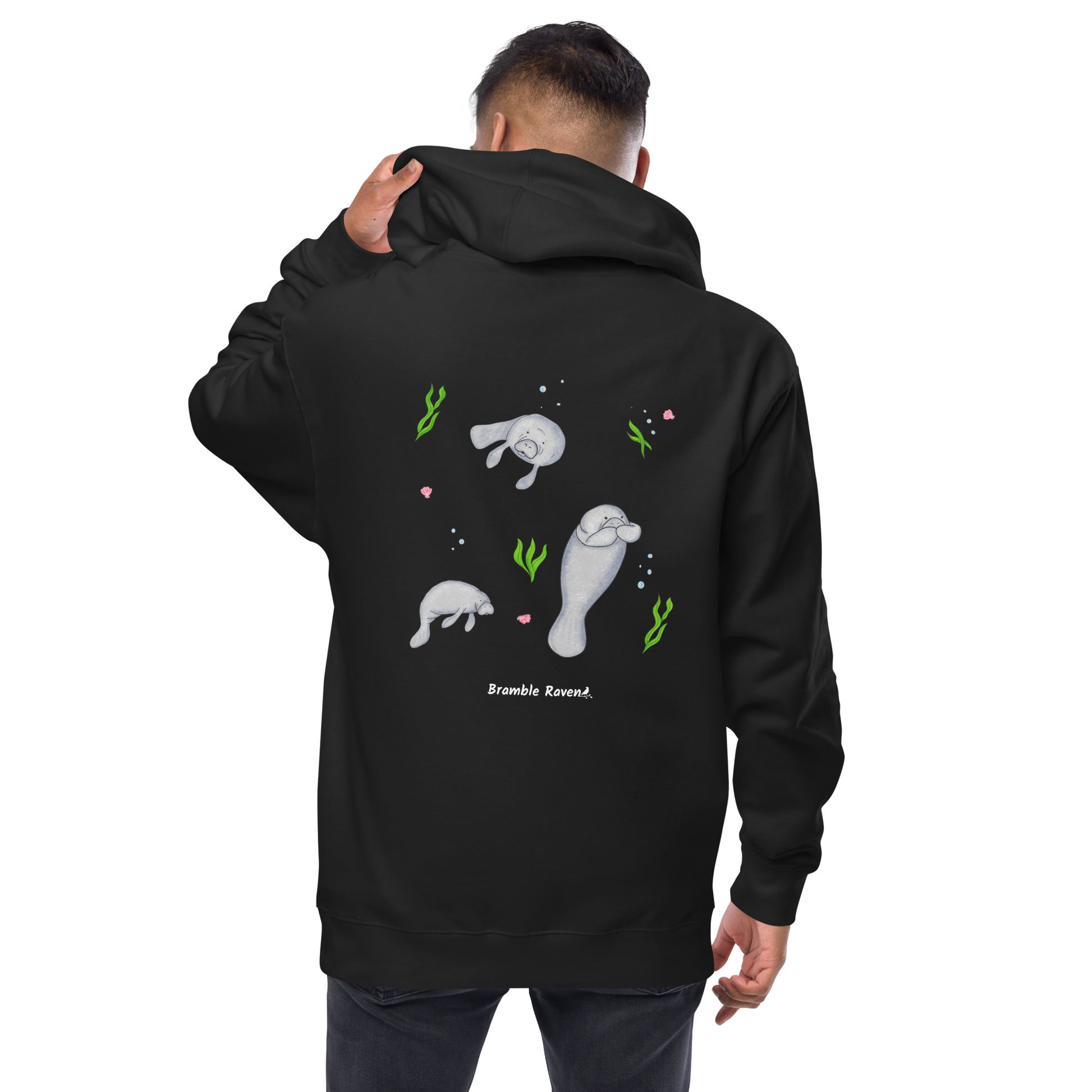 Black colored unisex zip-up hoodie. Features three manatees with seaweed, seashells, and bubbles on the back. It is made of soft, premium quality fleece fabric and has a jersey-lined hood. Made with 100% cotton face and 80% cotton, 20% polyester blend fleece. Features metal eyelets and zipper. Back view shown on male model.