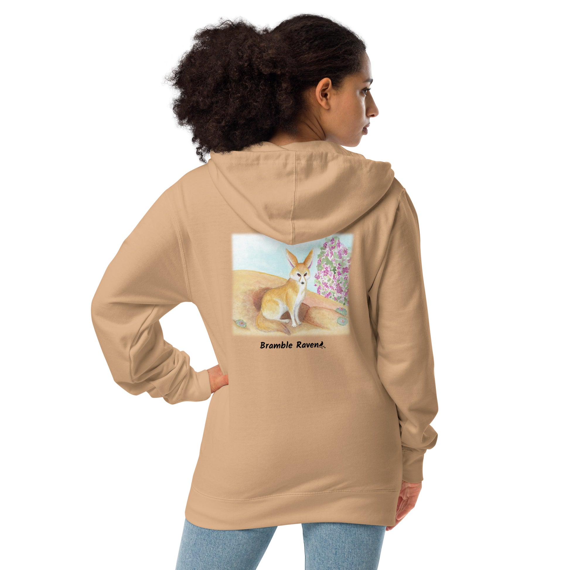 Unisex fleece-lined zip-up sandstone colored hoodie. Features original watercolor painting of a fennec fox in the desert on the back of the hoodie. Shown on female model.