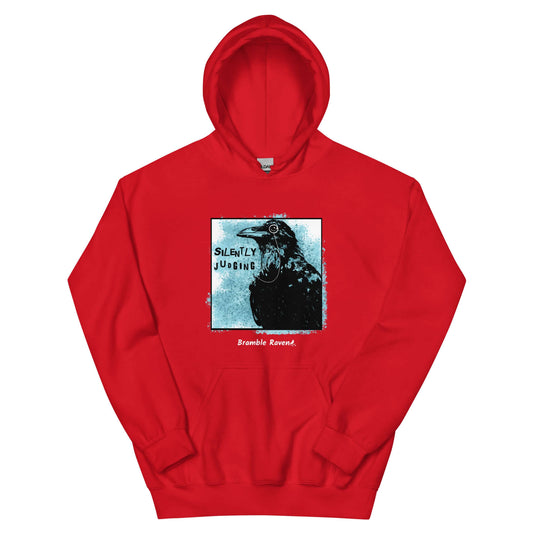 Unisex red colored hoodie with silently judging text by black crow wearing a monocle in a square with blue paint splatters.  Design on the front of hoodie.