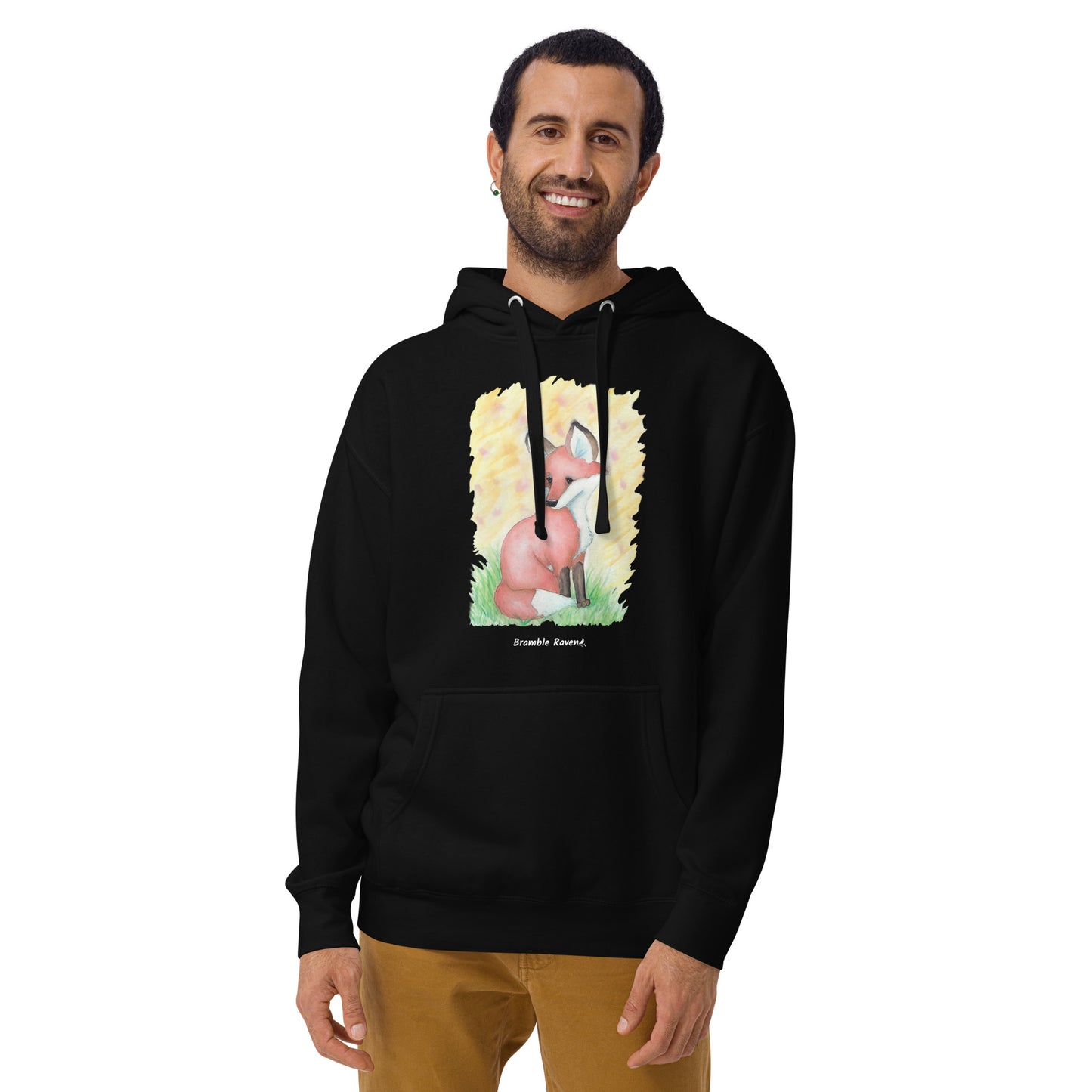 Unisex black colored hoodie. Features original watercolor painting of a fox in the grass against a yellow backdrop. Shown on male model.