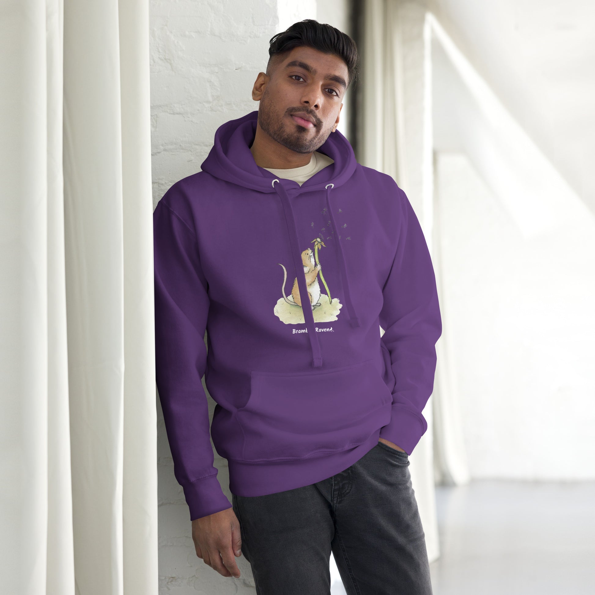 Original Dandelion wish design of cute watercolor mouse blowing dandelion seeds  featured on unisex purple colored hoodie shown on male model
