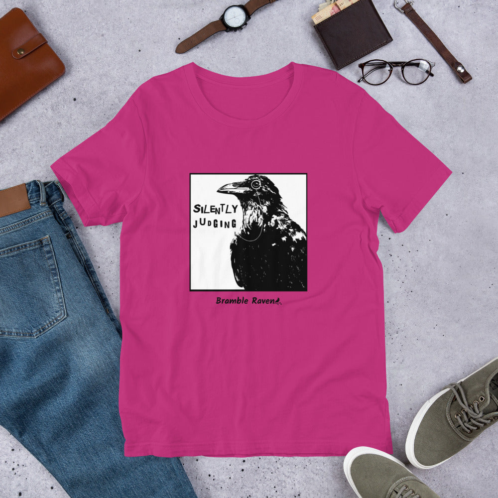 Unisex berry pink colored t-shirt. Features silently judging text next to black crow wearing a monocle in a square frame on a white background. 