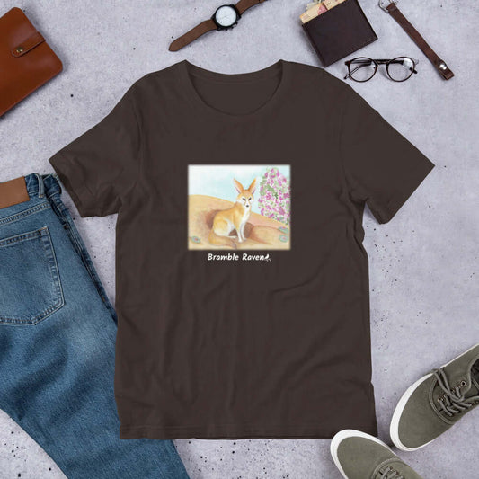 Unisex brown colored t-shirt. Features original watercolor painting of a fennec fox in the desert.