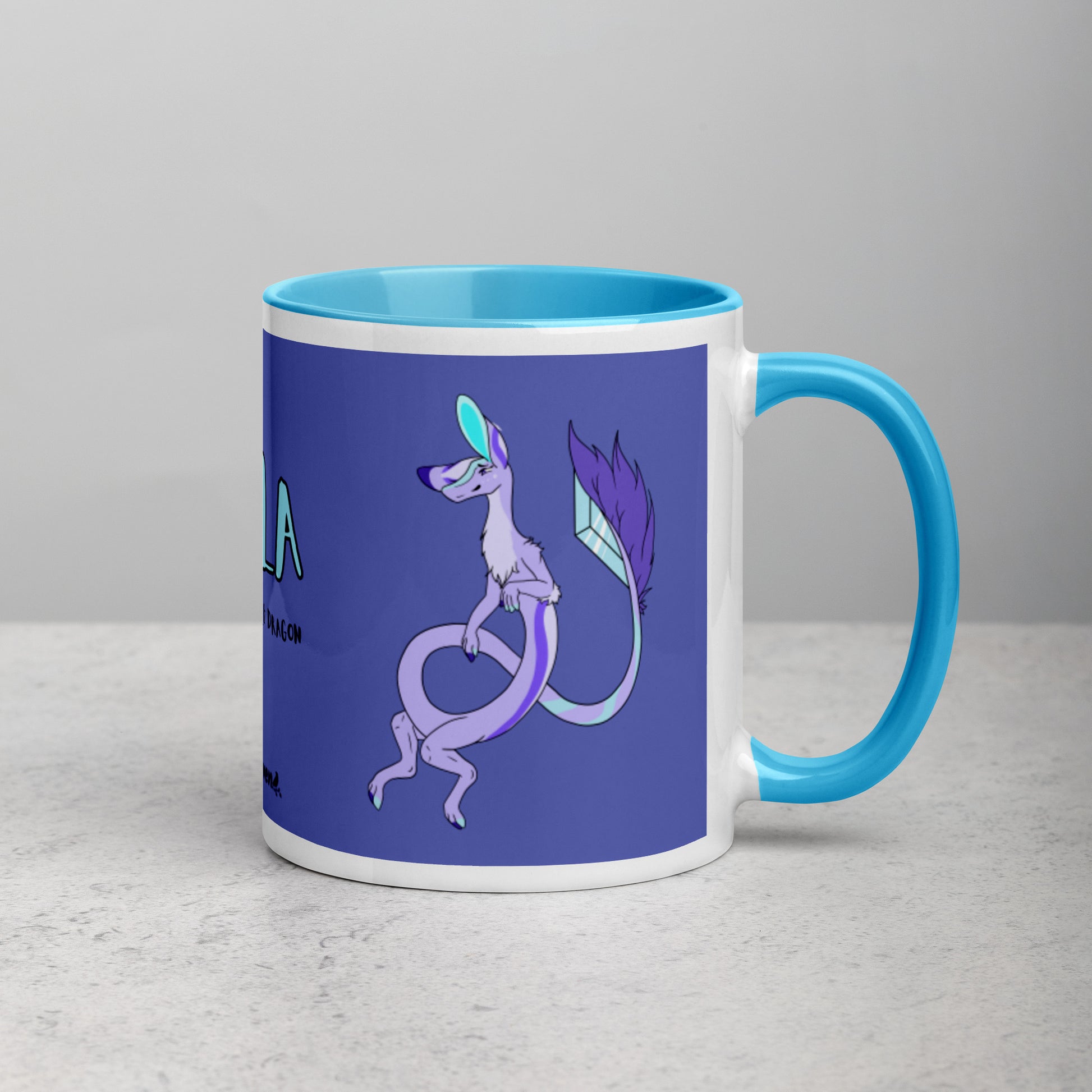 11 ounce white ceramic mug. Blue inside and handle. Features double-sided image of Layla the Lavender Fuzzy Noodle Dragon. Shown on tabletop with handle facing right.