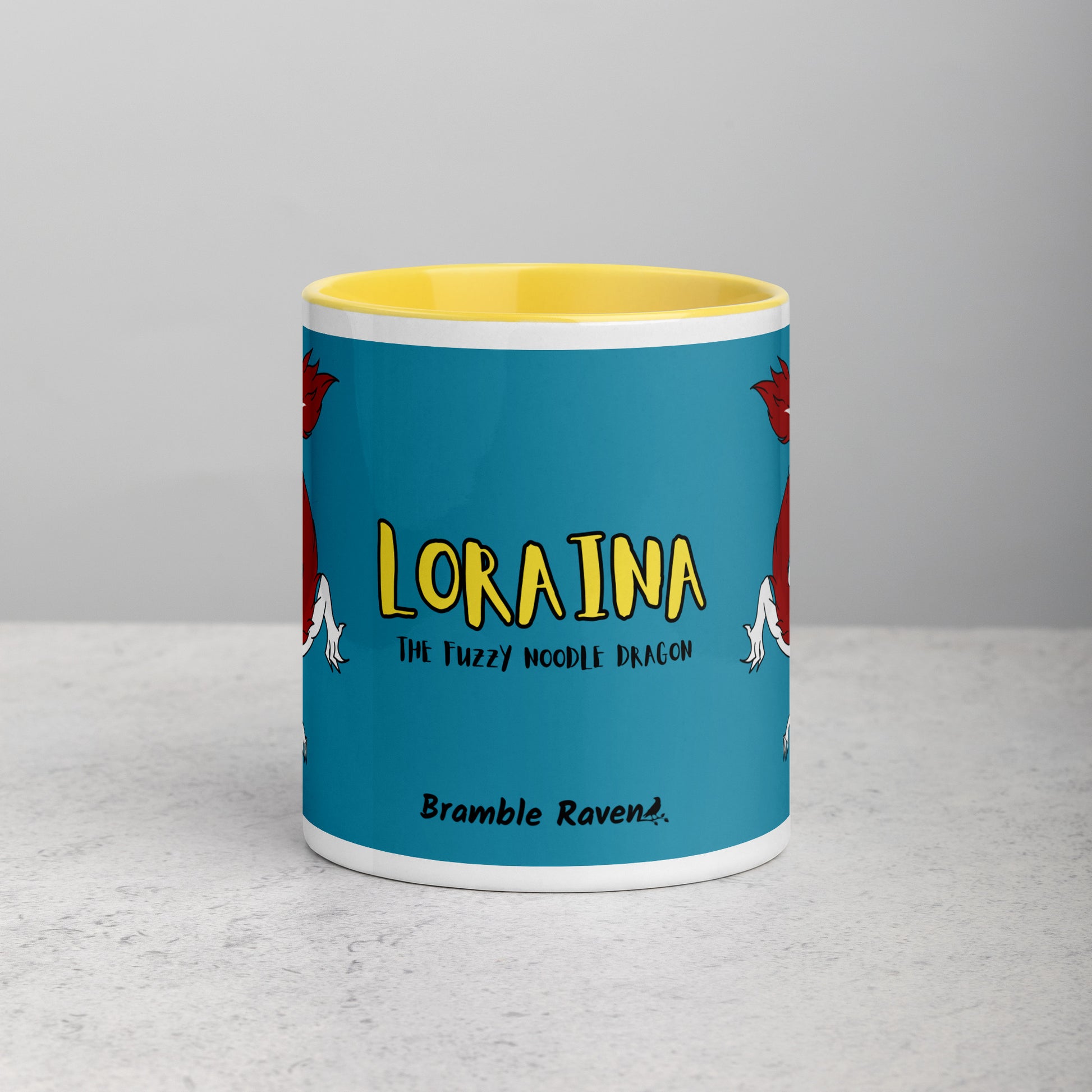 11 ounce ceramic mug with yellow handle, rim and inside color. Features double-sided image of Loraina the Fuzzy Noodle Dragon on a dark blue background. Mug is microwave and dishwasher safe. Front view shows Loraina the Fuzzy Noodle Dragon text and Bramble Raven logo.