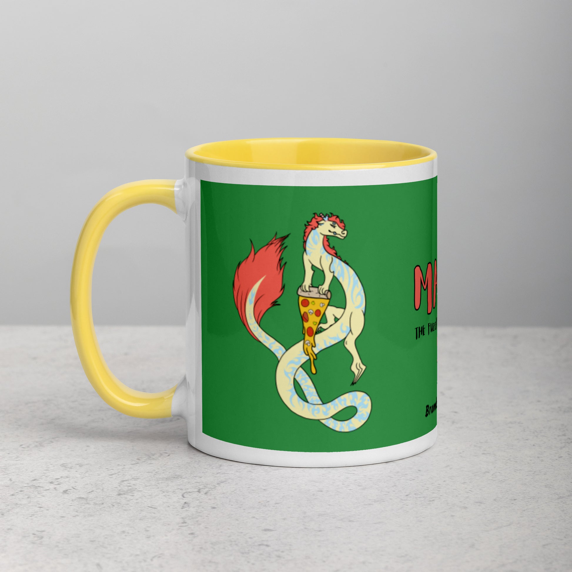 11 ounce white ceramic mug. Yellow inside and handle. Features double-sided image of Maisy the Fuzzy Noodle Dragon with a slice of pizza. Shown on tabletop.